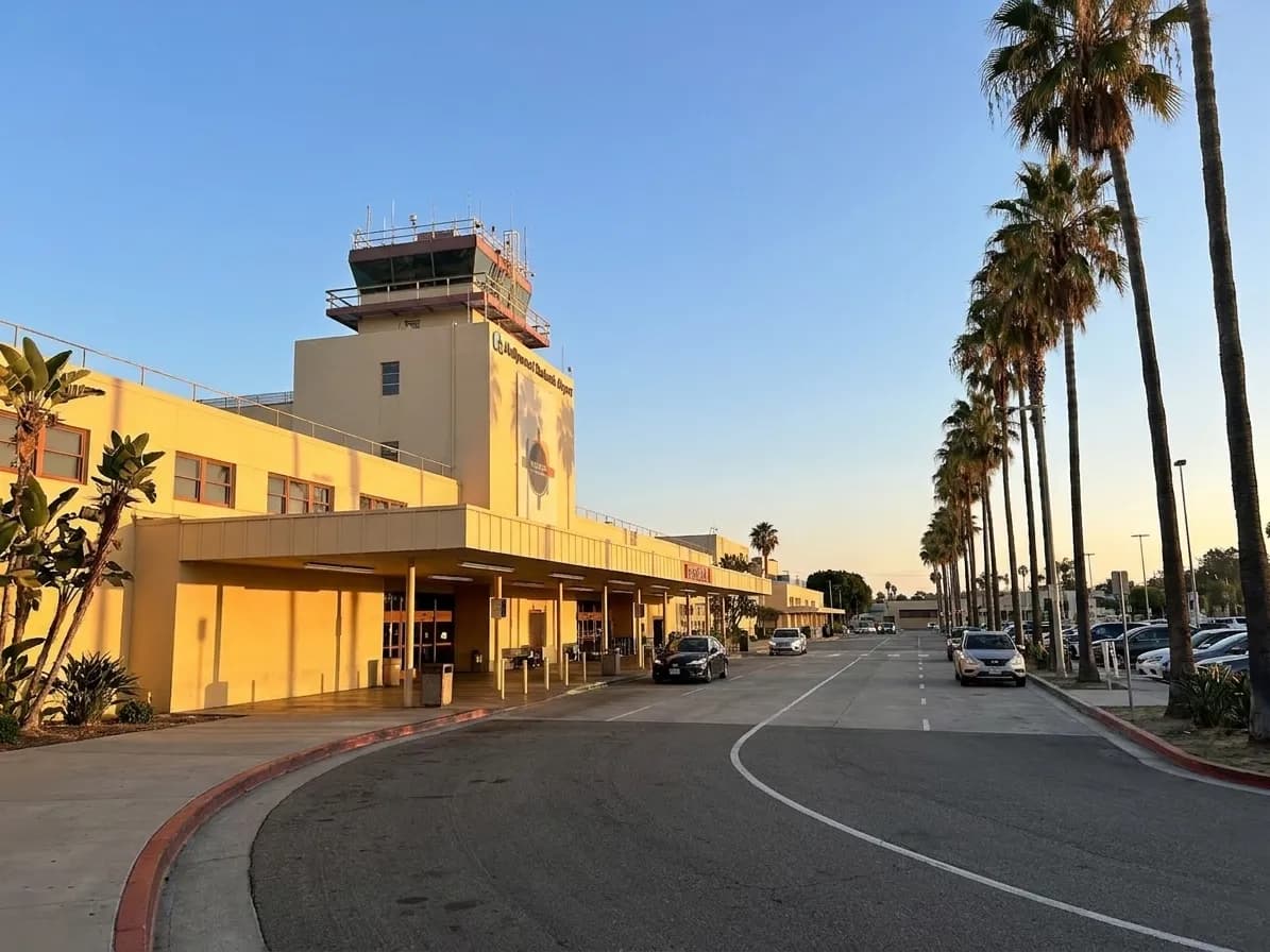 Hollywood Burbank Airport's compact terminal building with its distinctive mid-century architecture and palm trees along the entrance drive