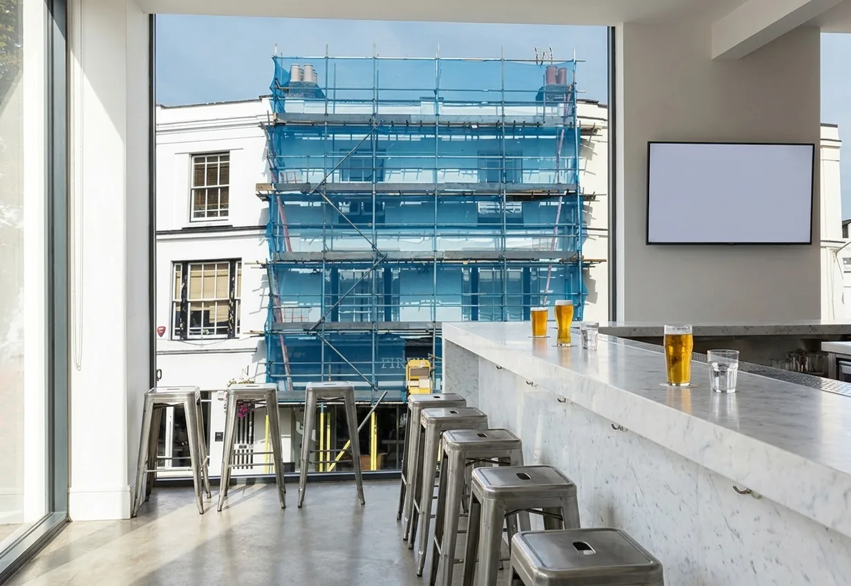 A bright modern bar interior at lunchtime with a screen on the far wall