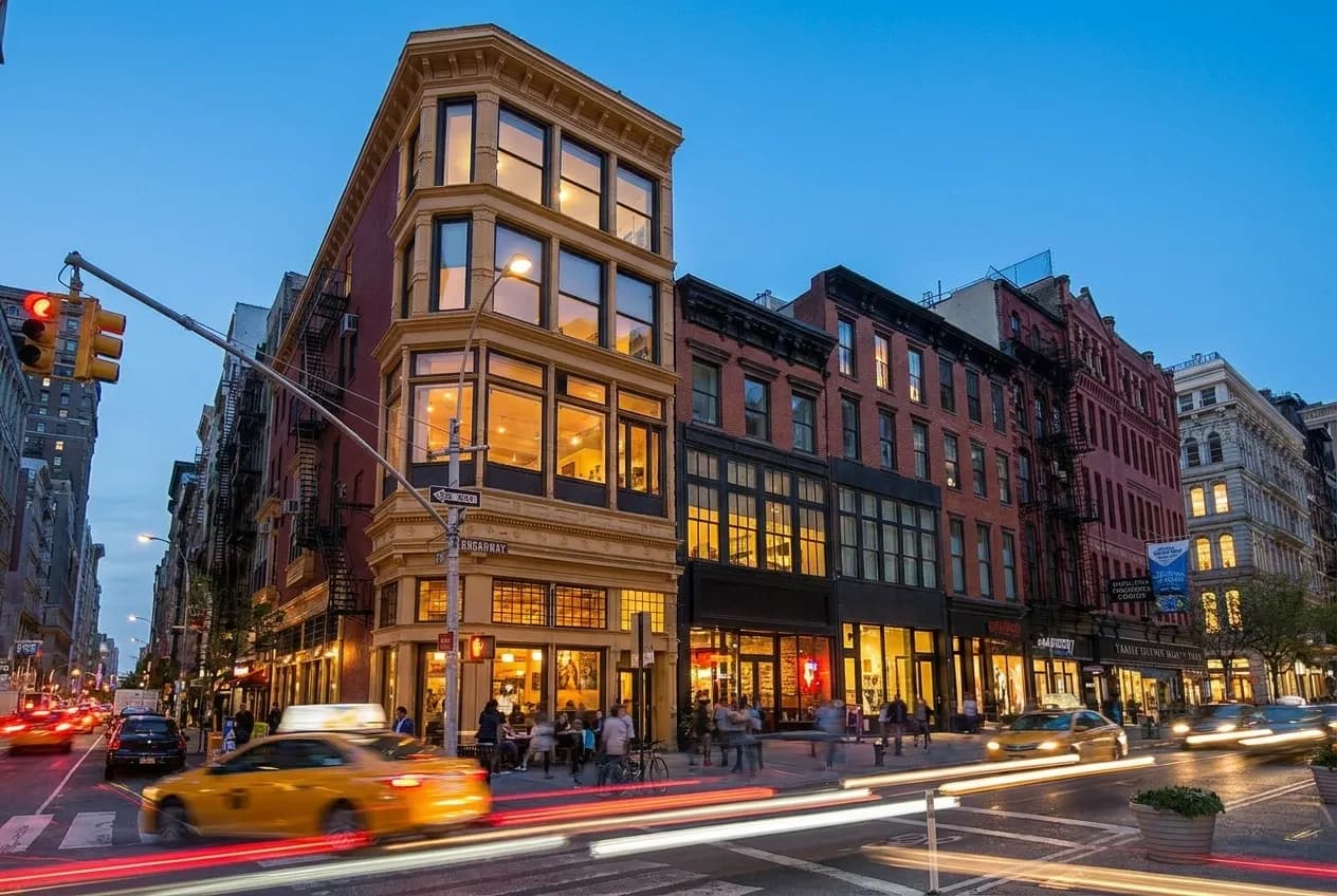 East 14th Street in Union Square at dusk with pedestrians, storefronts, and traffic under evening light.