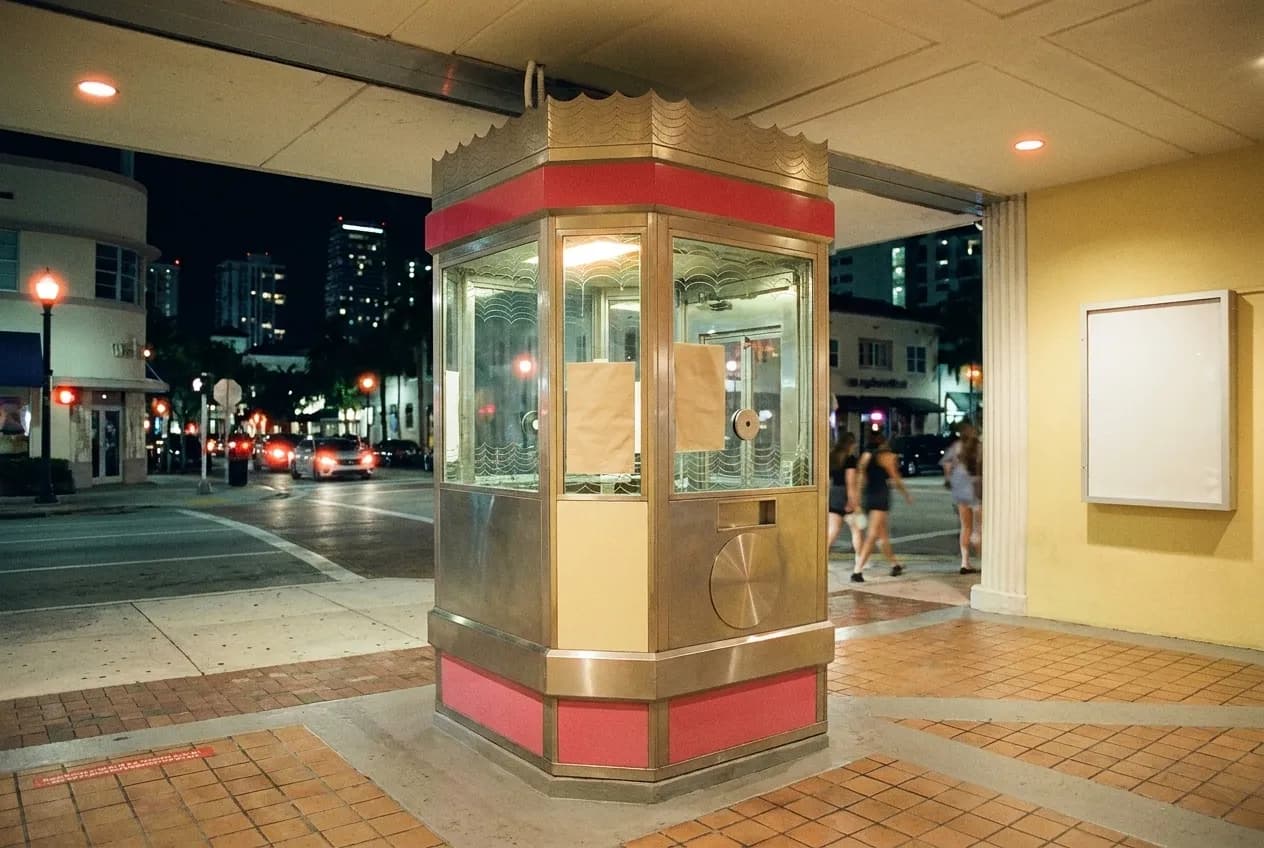 An Art Deco theatre tower on a boulevard corner lit at night in Los Angeles