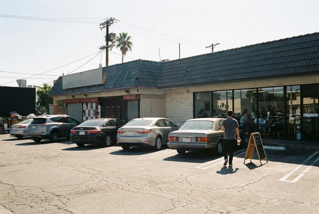 A small Los Angeles café in a strip mall with an empty parking lot in front