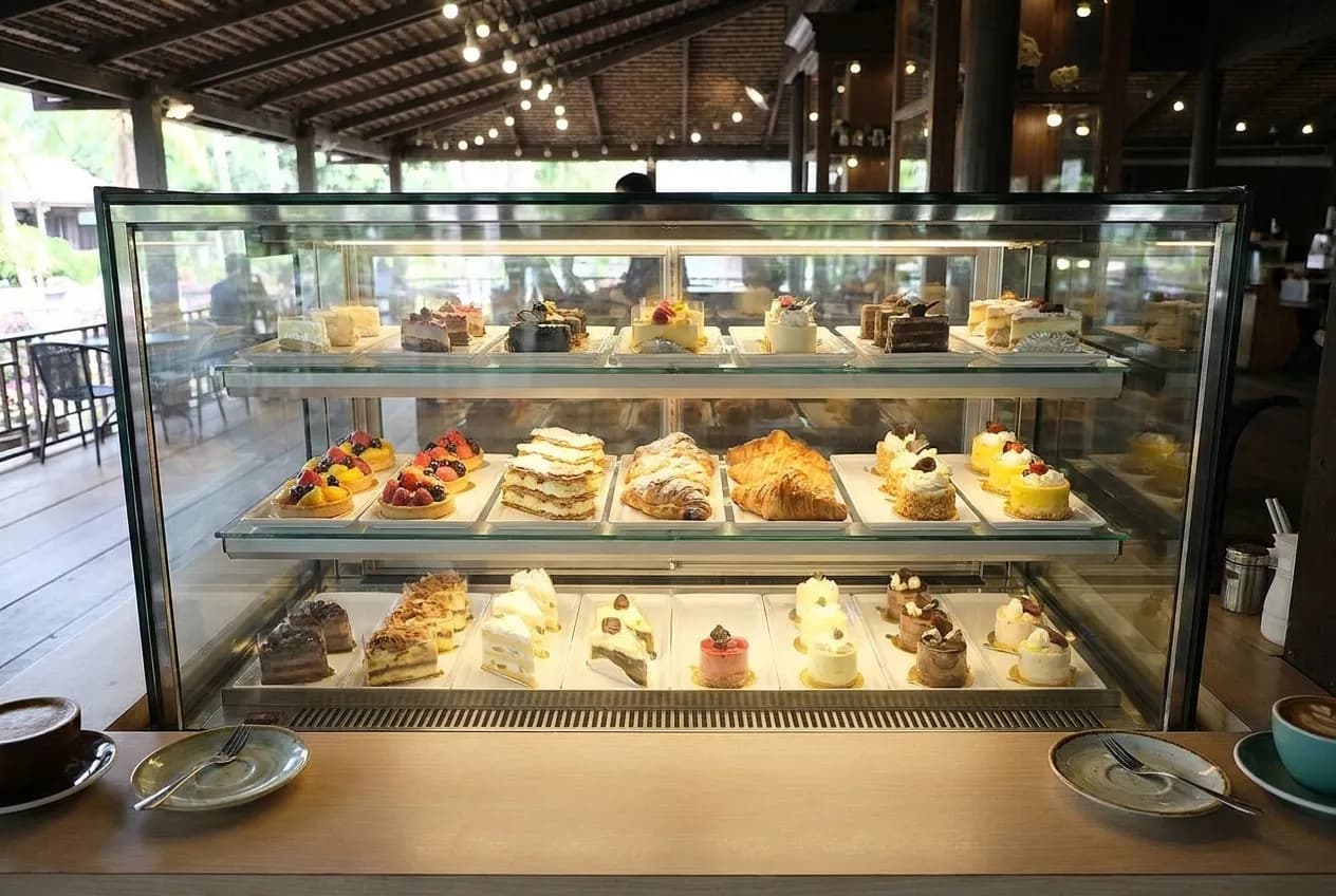 Overhead view of a dessert case displaying pastries and cakes at a cafe counter