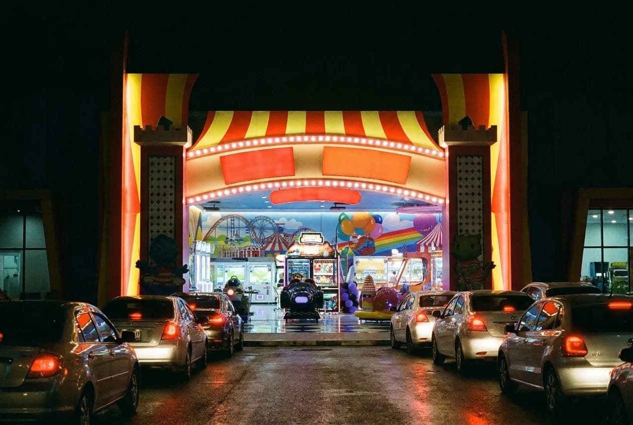 A venue marquee glowing above a street with cars queuing beneath