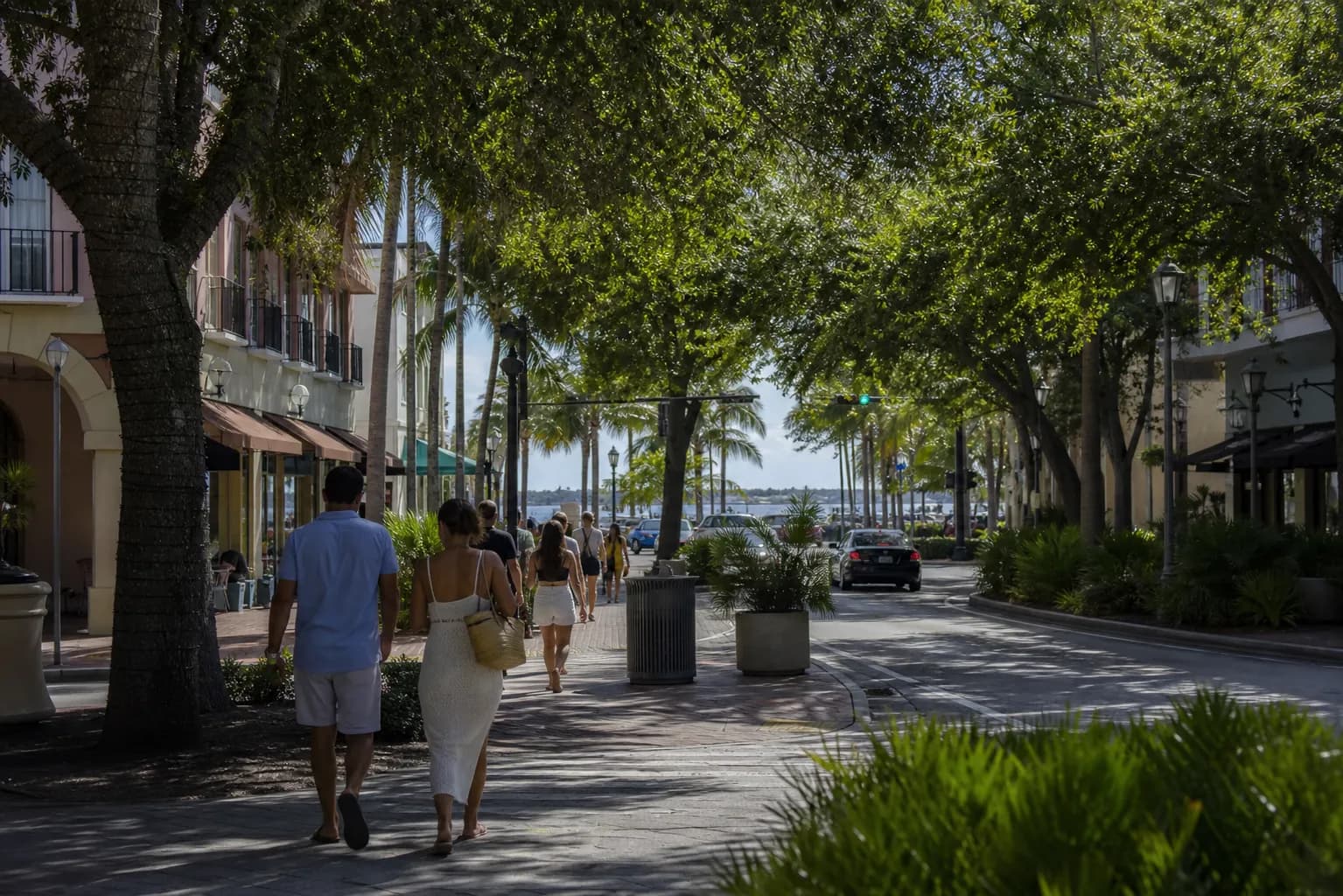 People walking along a shaded Coconut Grove street toward the waterfront