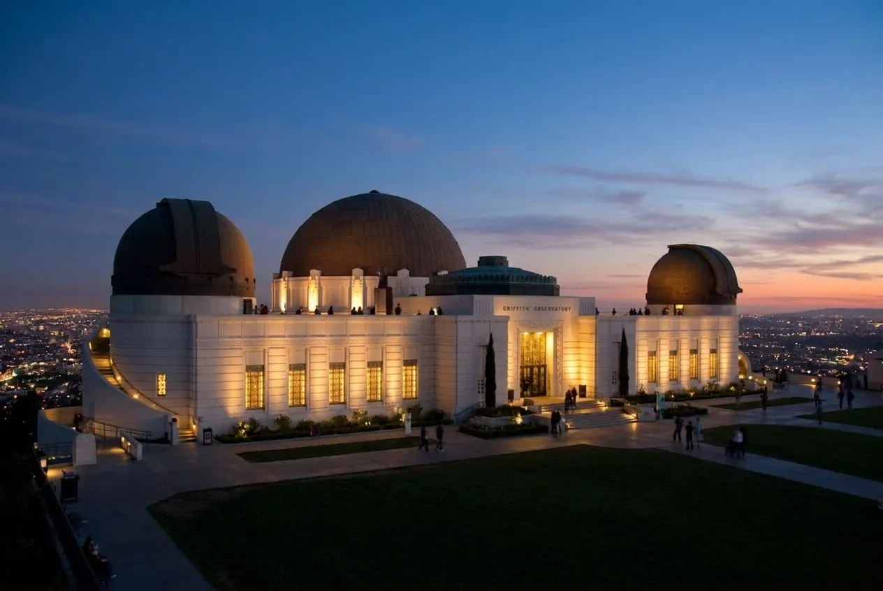 Griffith Observatory's white Art Deco dome and terrace overlooking Los Angeles at dusk