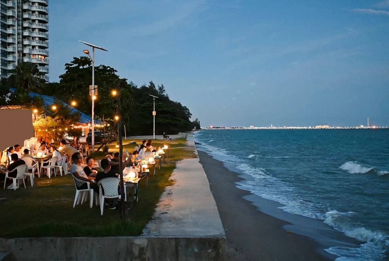 An ocean horizon seen from a restaurant terrace at dusk with a low sun