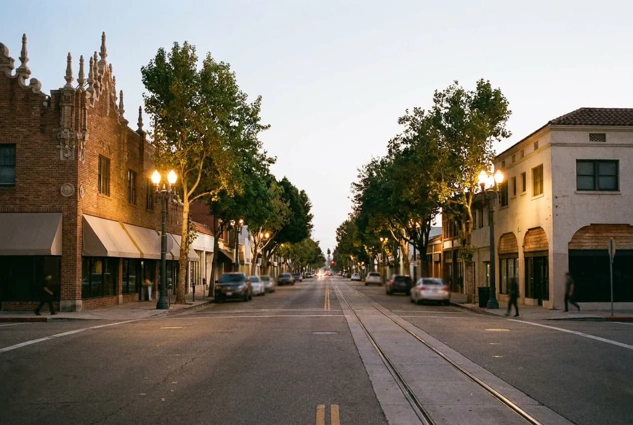 A short village high street in Los Angeles at dusk with awnings and street trees