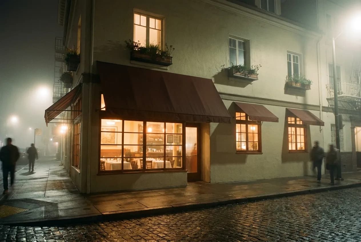 A lit restaurant window glowing on a dark foggy residential street near the ocean in San Francisco