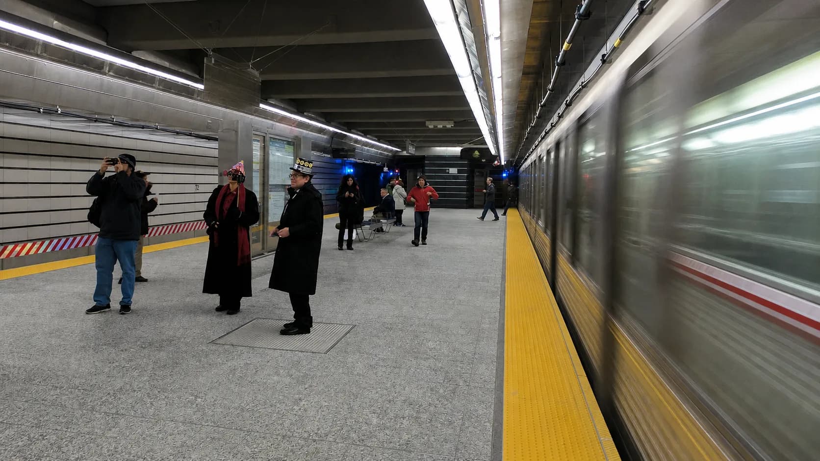 New Yorkers waiting on a subway platform while heading to an evening movie screening.