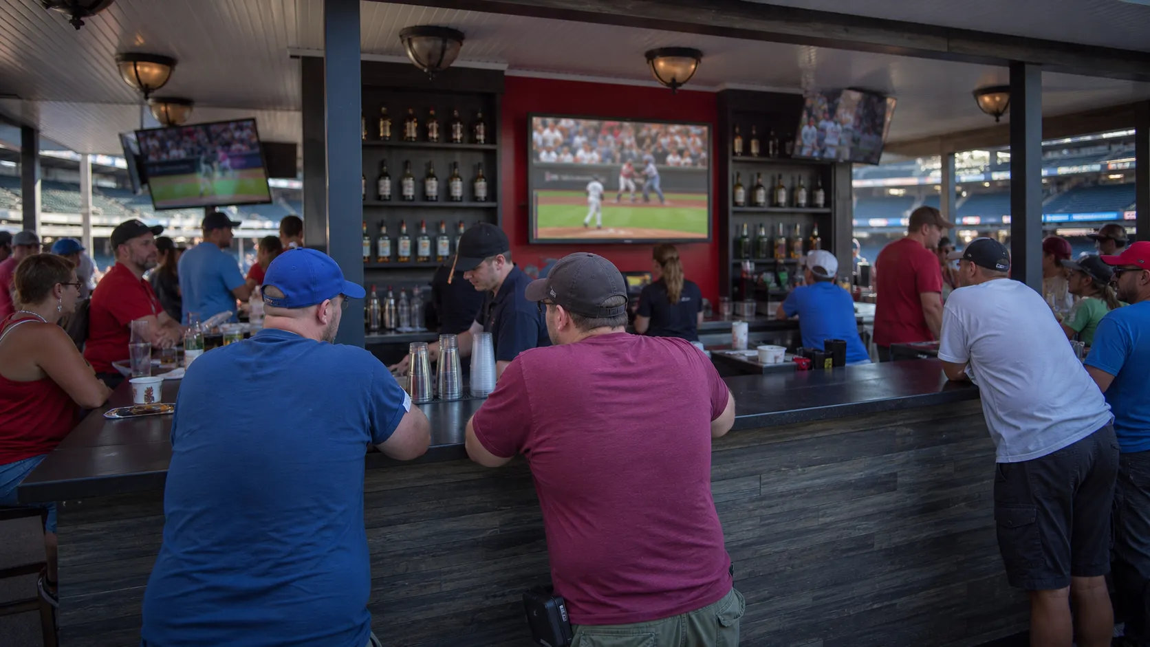 Crowded NYC sports bar interior with baseball on several televisions.