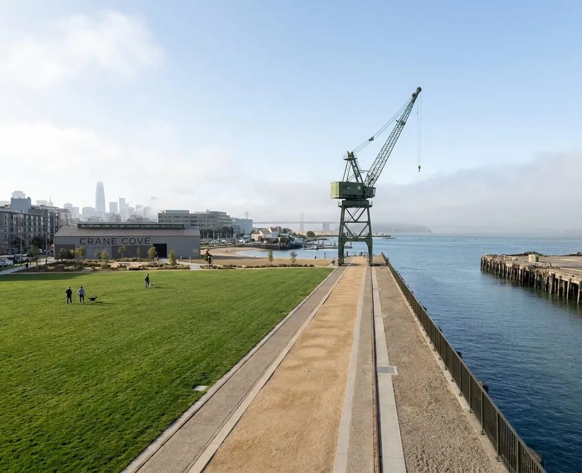 Crane Cove Park waterfront path with Bay light and a distant skyline