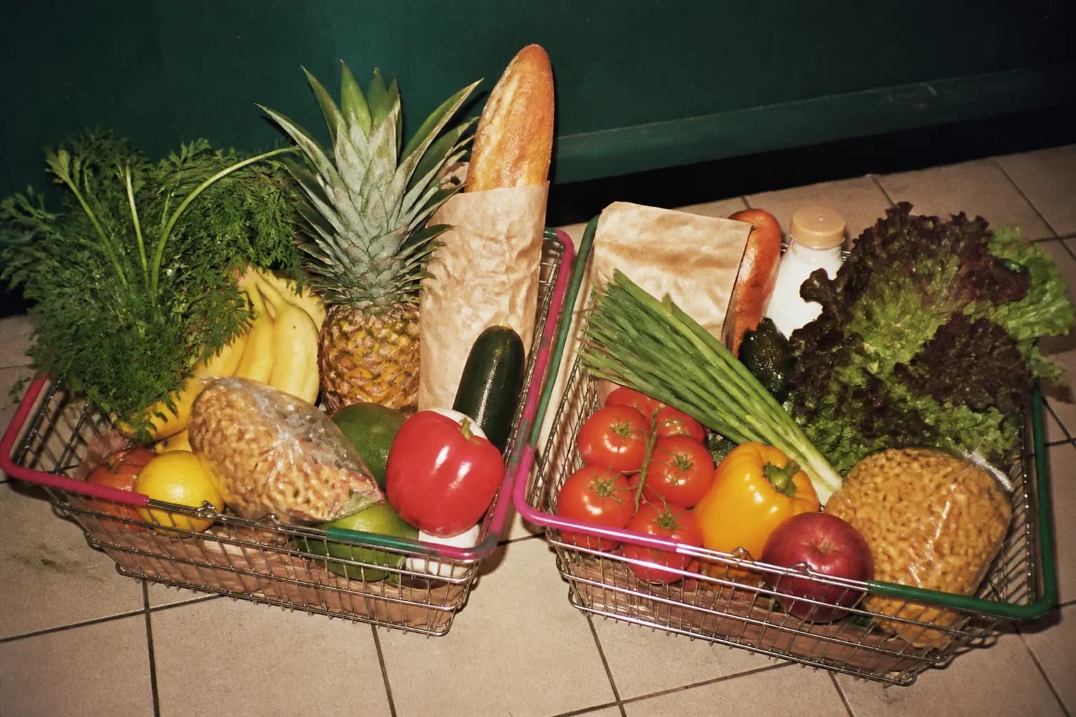 Two budget shopping baskets filled with everyday goods set side by side on a counter