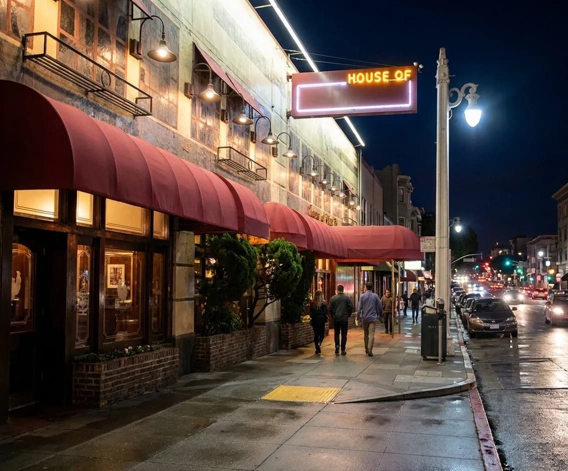Warm-lit old-school steakhouse exterior on a San Francisco corner at night