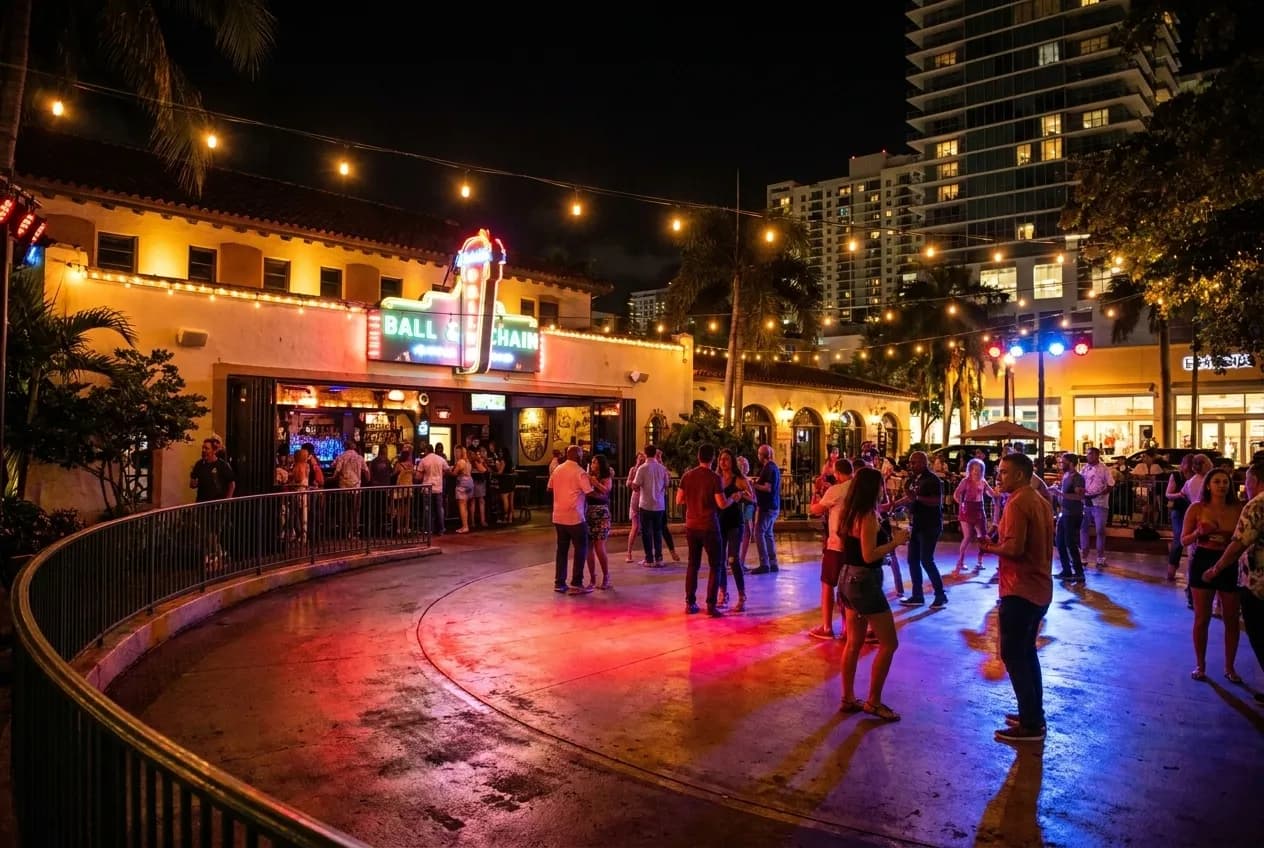 String lights and colored spotlights illuminate an outdoor courtyard stage at Ball & Chain on Calle Ocho, with dancers moving across tile floors under tropical murals.