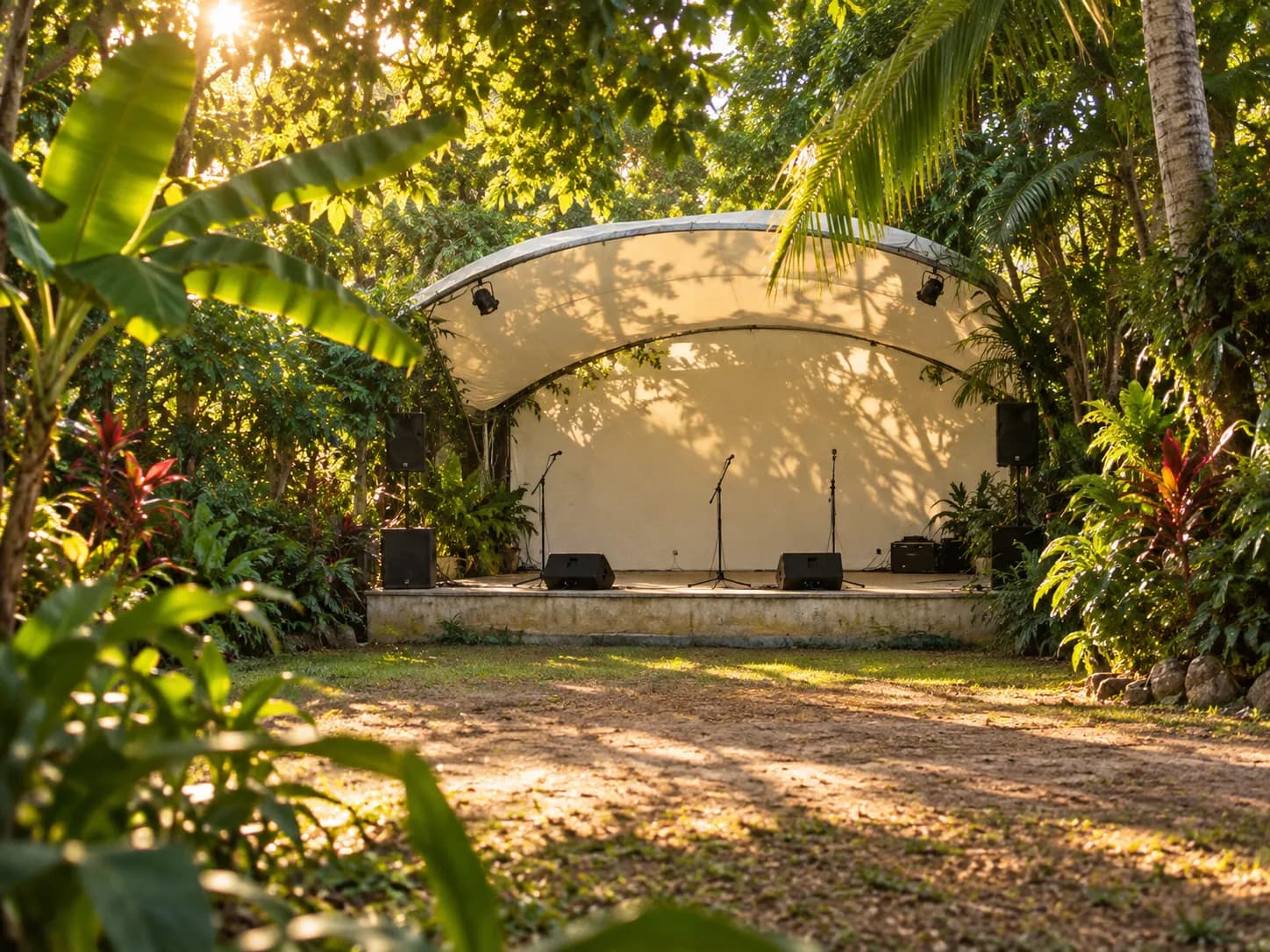 A small covered stage in a tropical garden with instruments set up and no audience