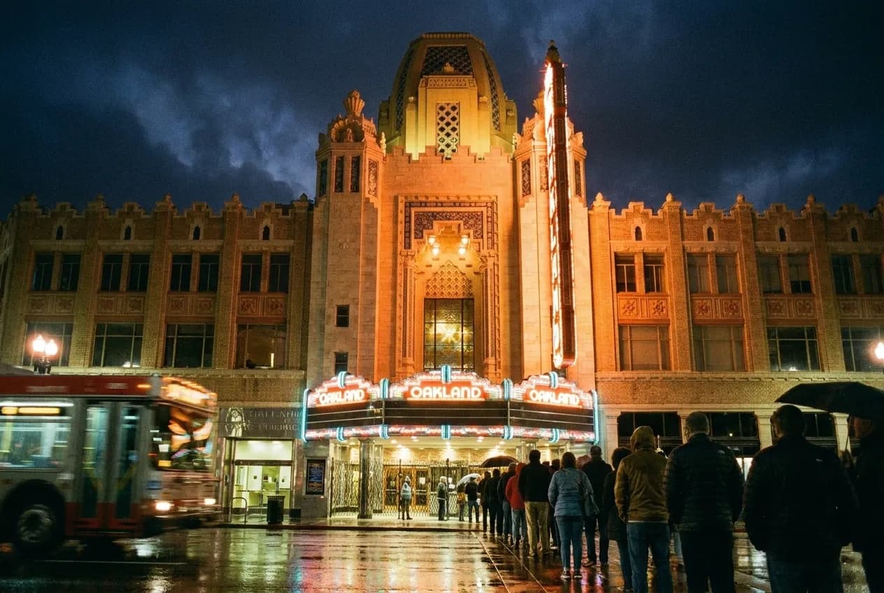 A restored theatre marquee glowing over an Oakland street at night