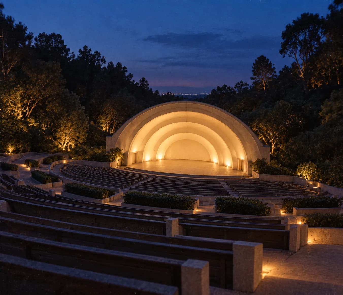 A large concentric-arched band shell facing tiered seating in a wooded canyon