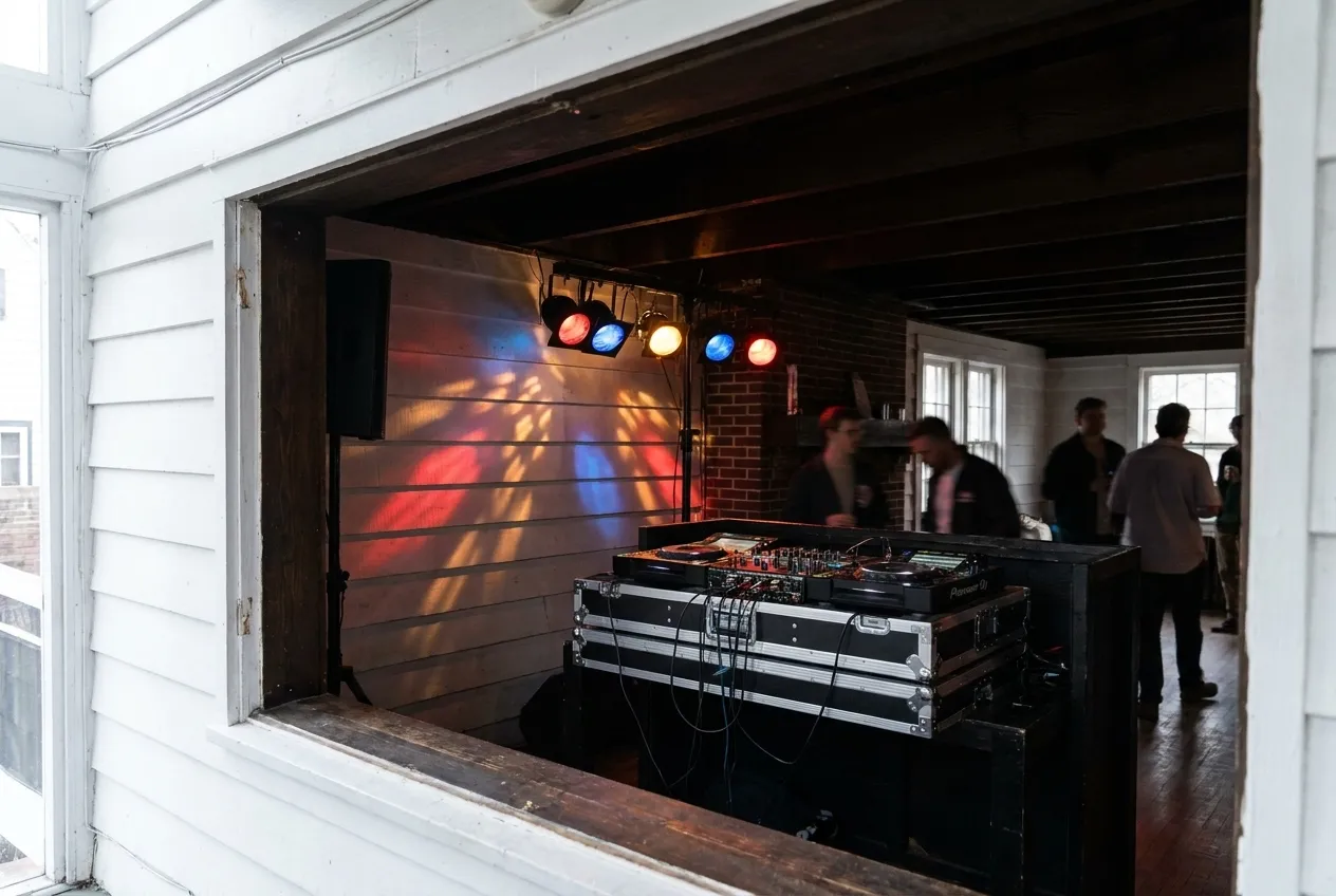 A low-ceilinged club interior with a mixing desk and coloured lights on the wall