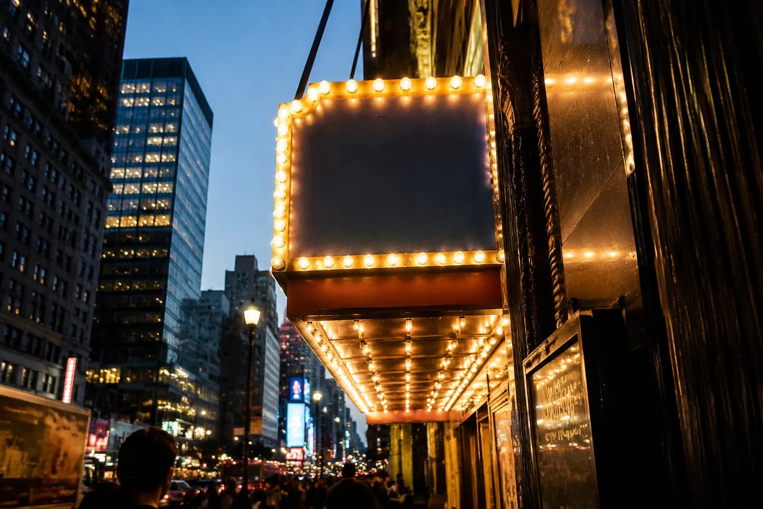 Broadway theater marquee illuminated at dusk on West 44th Street in the Theater District