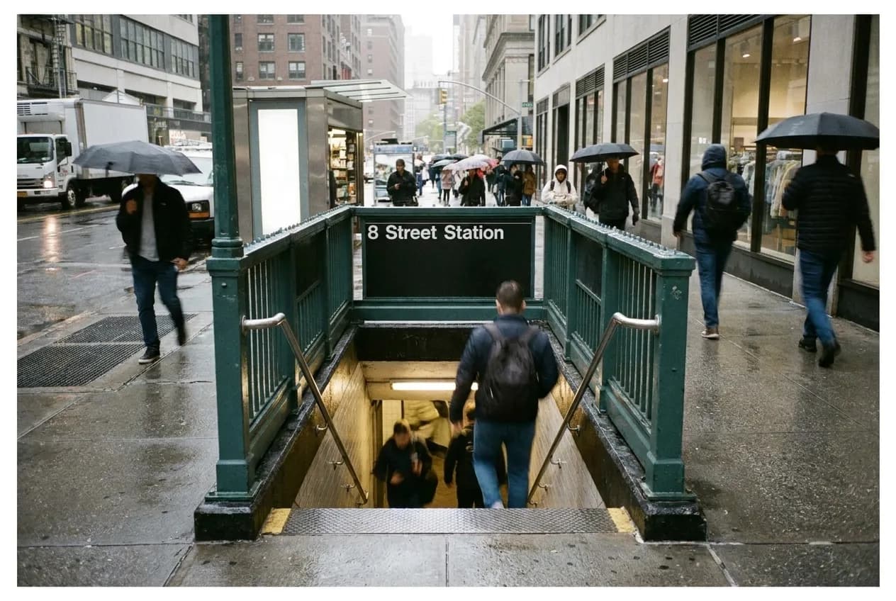 New York City subway station entrance with pedestrians on surrounding sidewalk