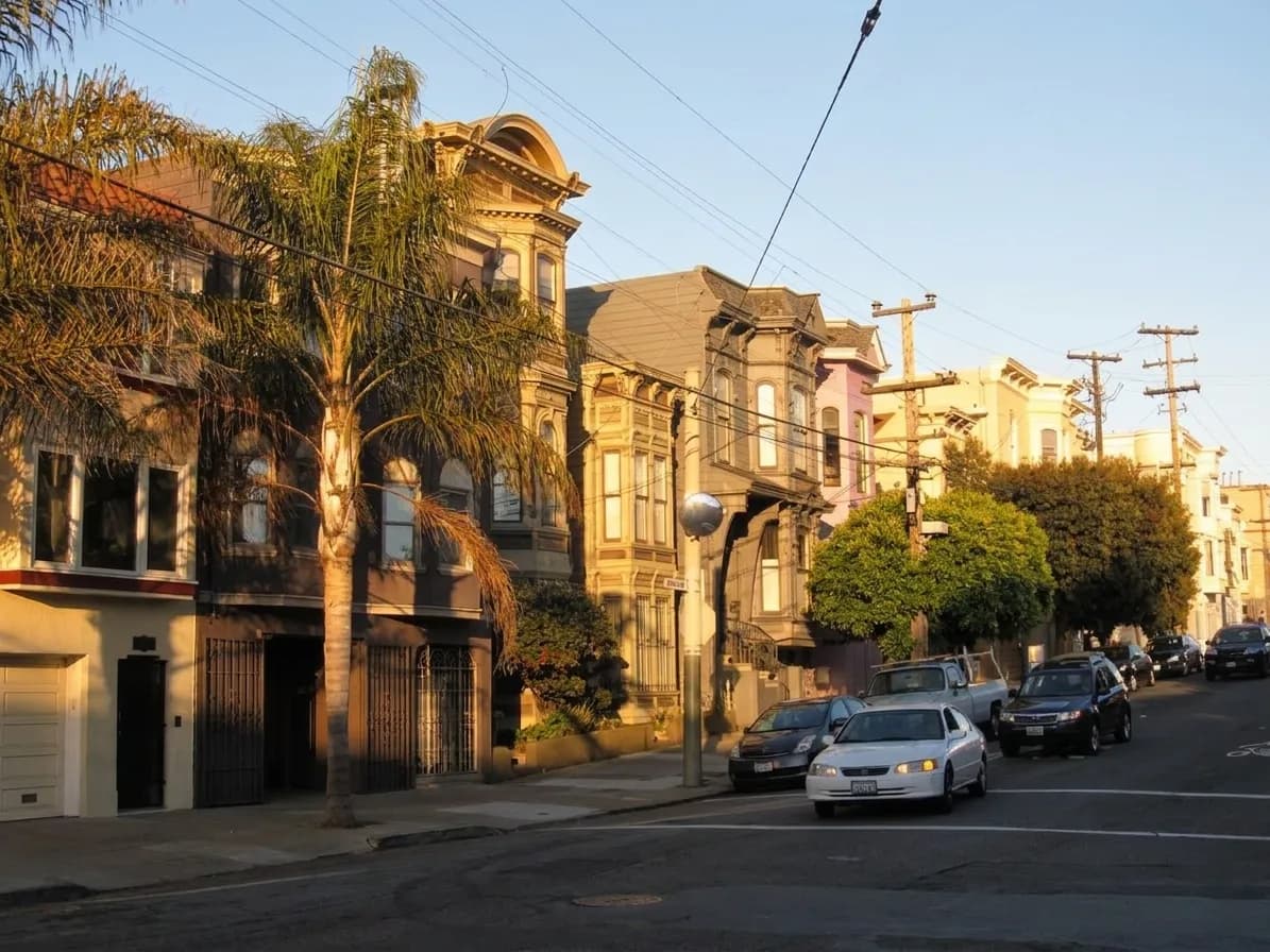 Residential Waller Street block in Haight-Ashbury with Victorian buildings and parked cars under afternoon light