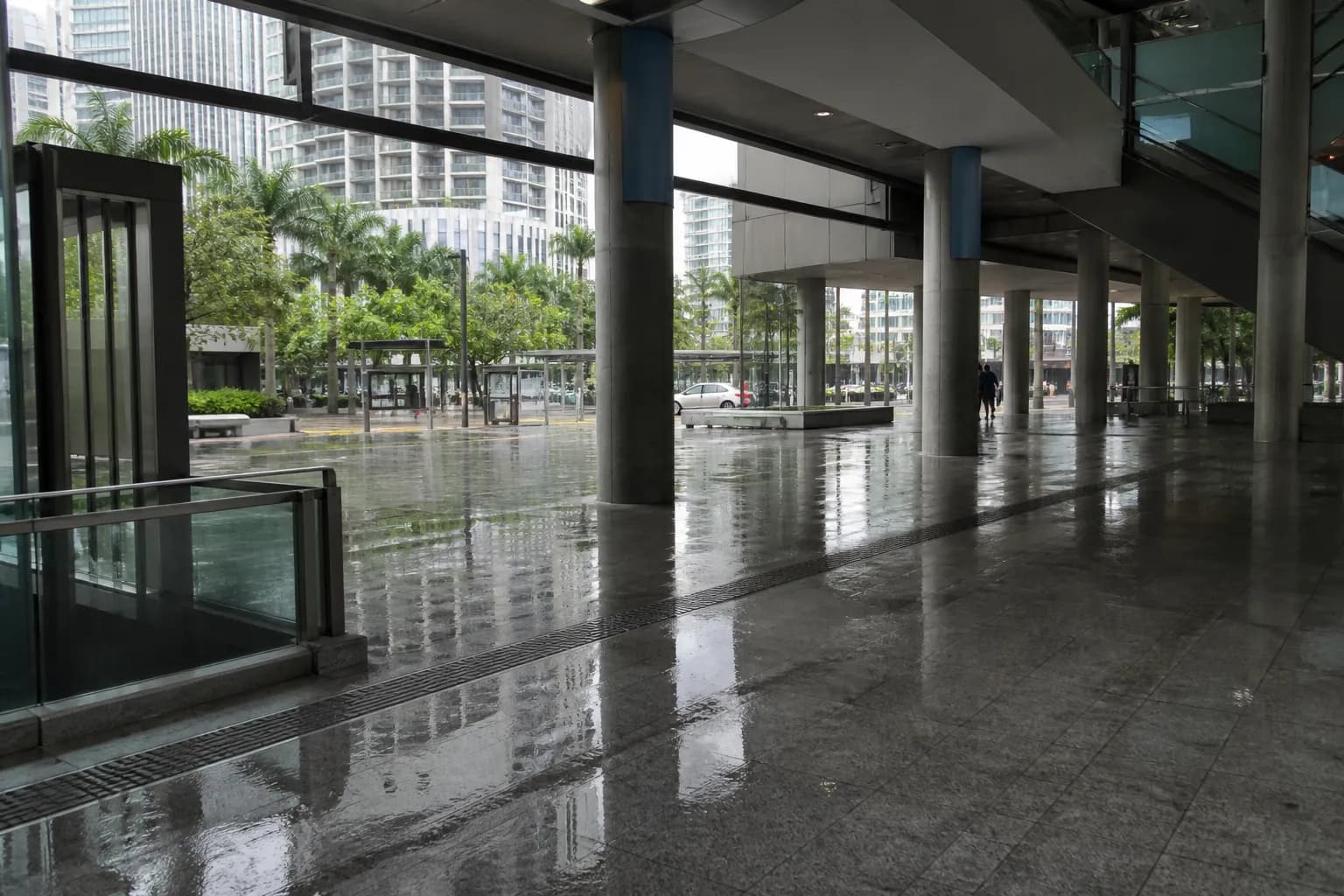 Rainy downtown Miami Metromover station with wet concrete and glass towers