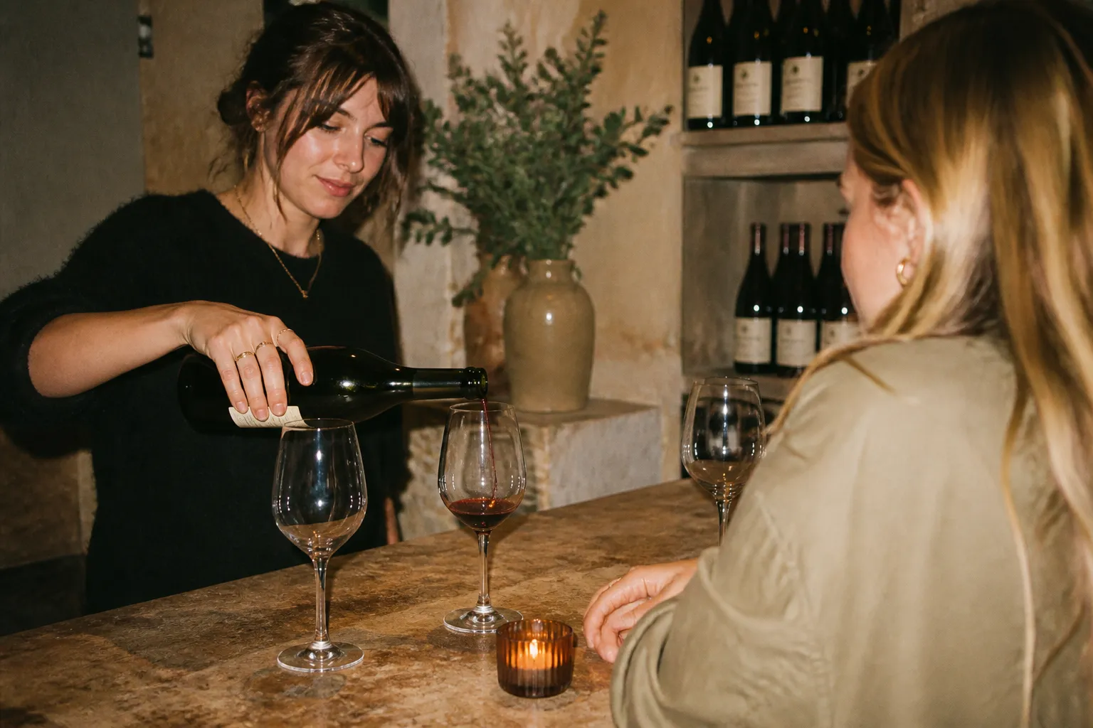 A small pour of red wine in a glass on a tasting counter