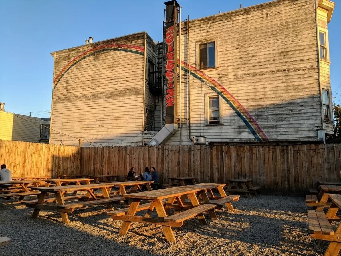 Gravel patio with long wooden picnic benches at Zeitgeist beer garden on Valencia Street