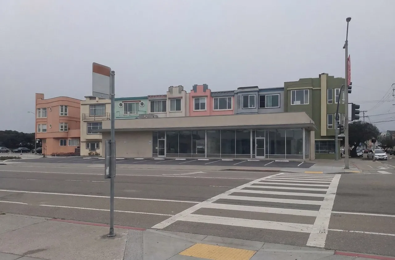 Commercial building on Sloat Boulevard in San Francisco's Sunset District with a dog and owner near the entrance.