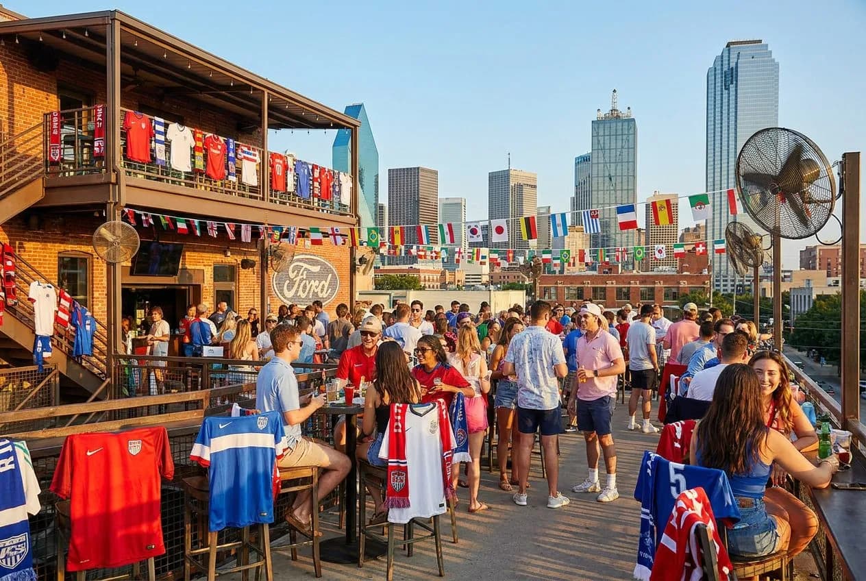 A stylish Dallas rooftop bar at golden hour with skyline views and fans enjoying drinks in bright, warm natural light with festive World Cup accents