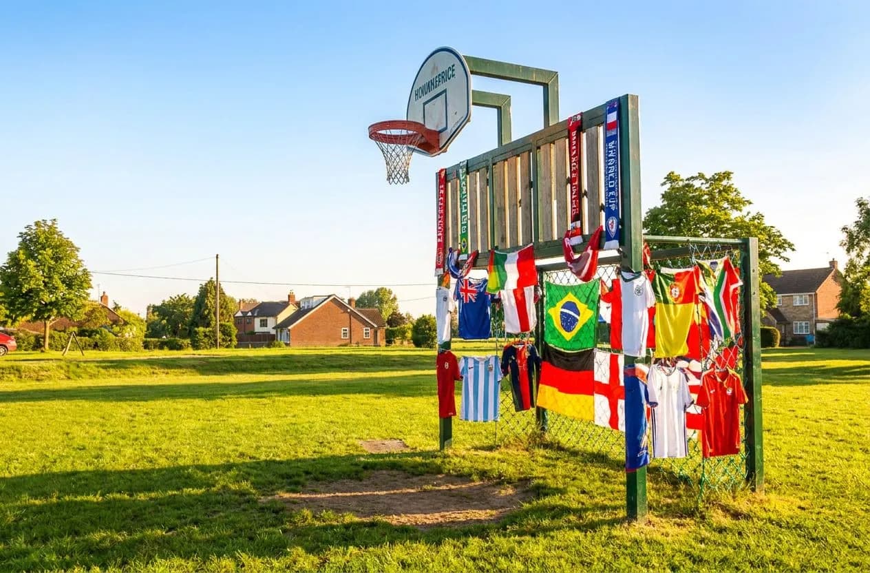 A goal net and defensive wall arrangement on a vivid green pitch under warm daylight, festive World Cup atmosphere with cheerful accents.