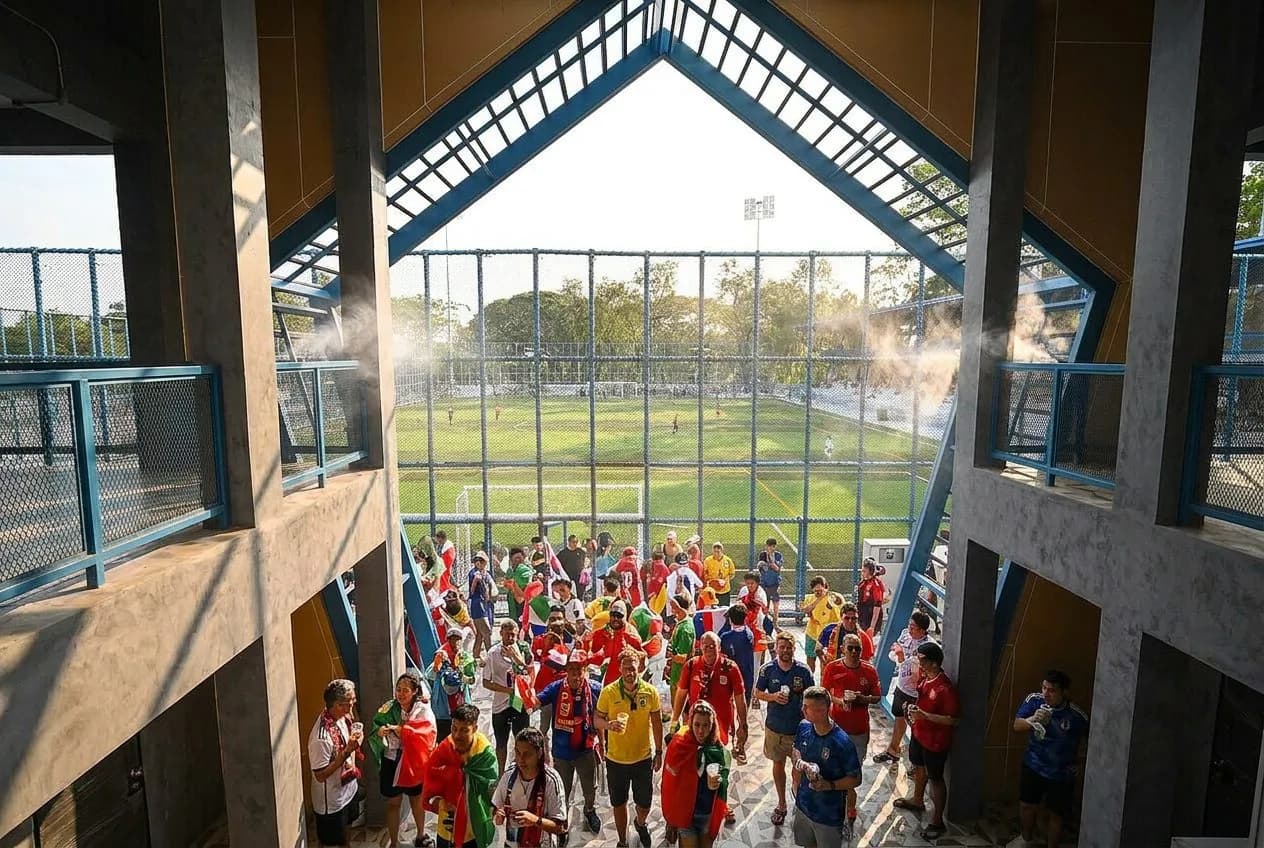 Shaded stadium concourse with fans in national team colors cooling off and gathering on a hot summer day