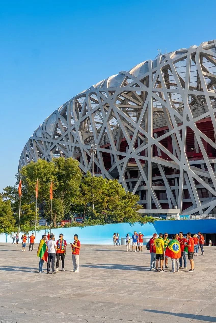 Modern stadium exterior gleaming under bright blue sky with festive flags gently waving in the breeze
