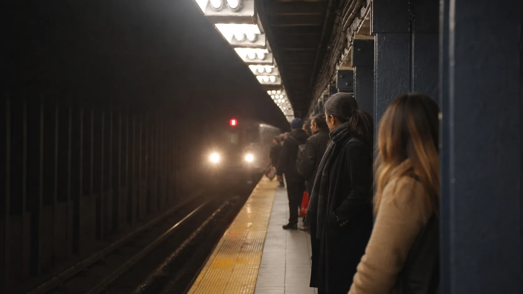 Subway riders move through a station near the American Museum of Natural History.