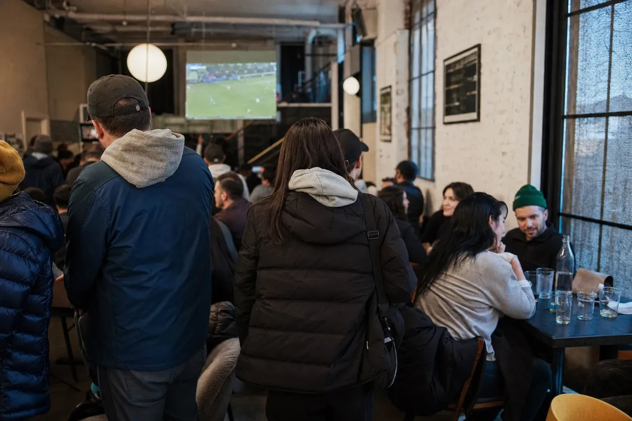 NYC experience scene for Gotham FC Away Match at Football Cafe: A LES Screen Plan for Solo Fans