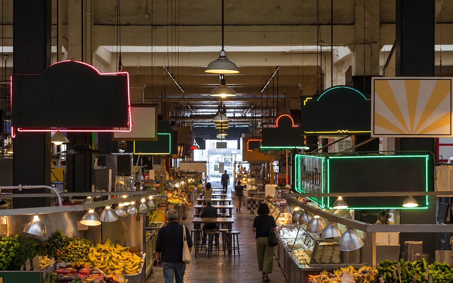 Wide interior of a historic downtown market hall looking down the central aisle, food stalls either side under vintage neon shapes, exposed ceiling and communal tables down the middle