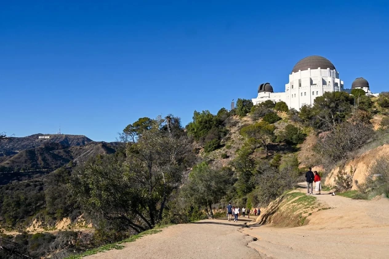 Wide hiking trail in Griffith Park with the observatory in the distance