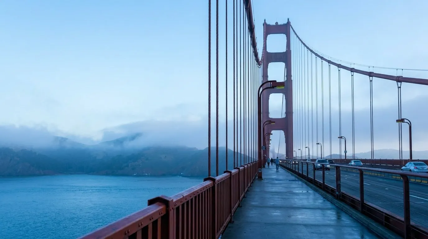 Golden Gate Bridge pedestrian sidewalk stretching toward Marin County with cables overhead and bay views on both sides