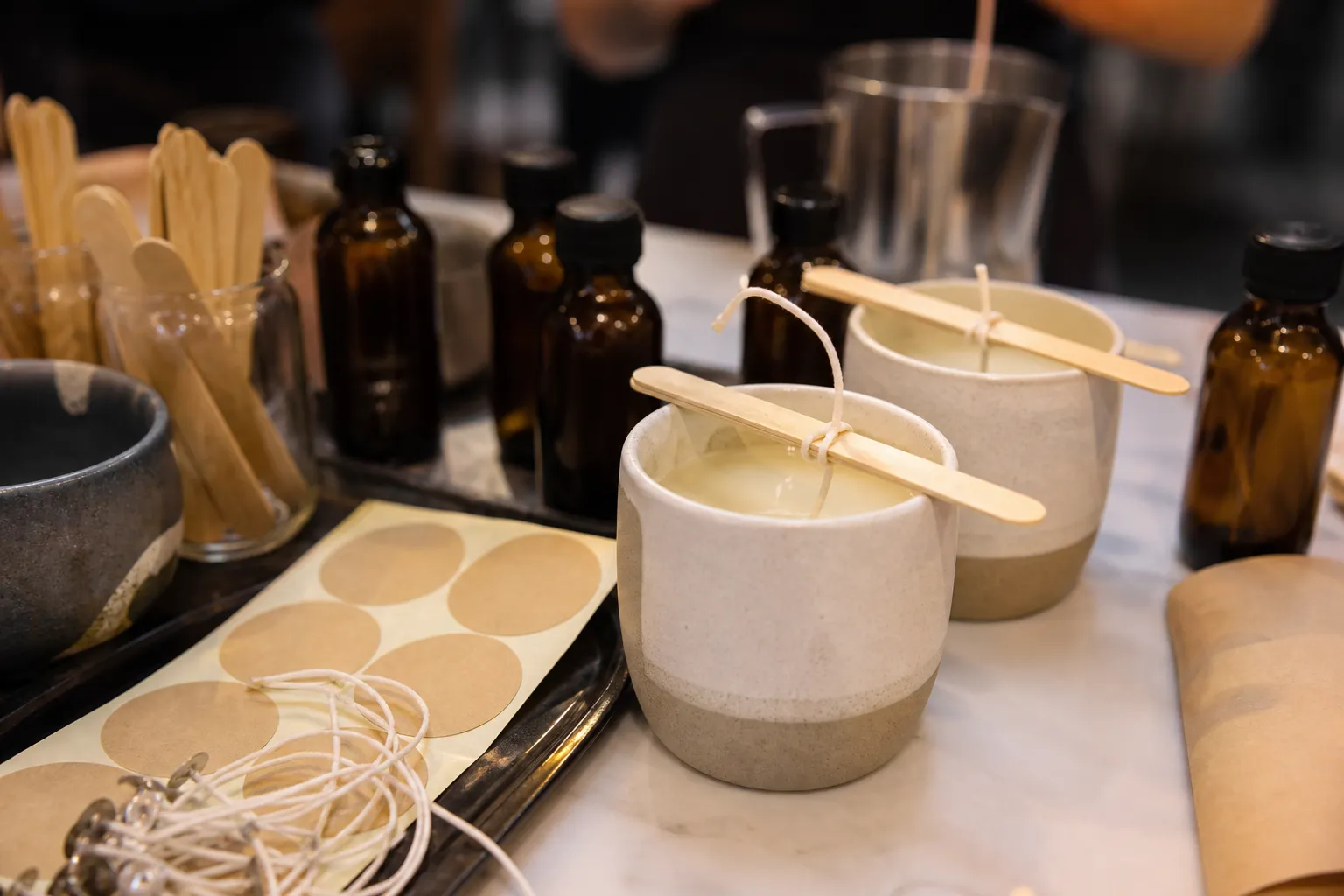 A candle workshop counter in Los Angeles with wax pitchers, jars, and neatly arranged tools