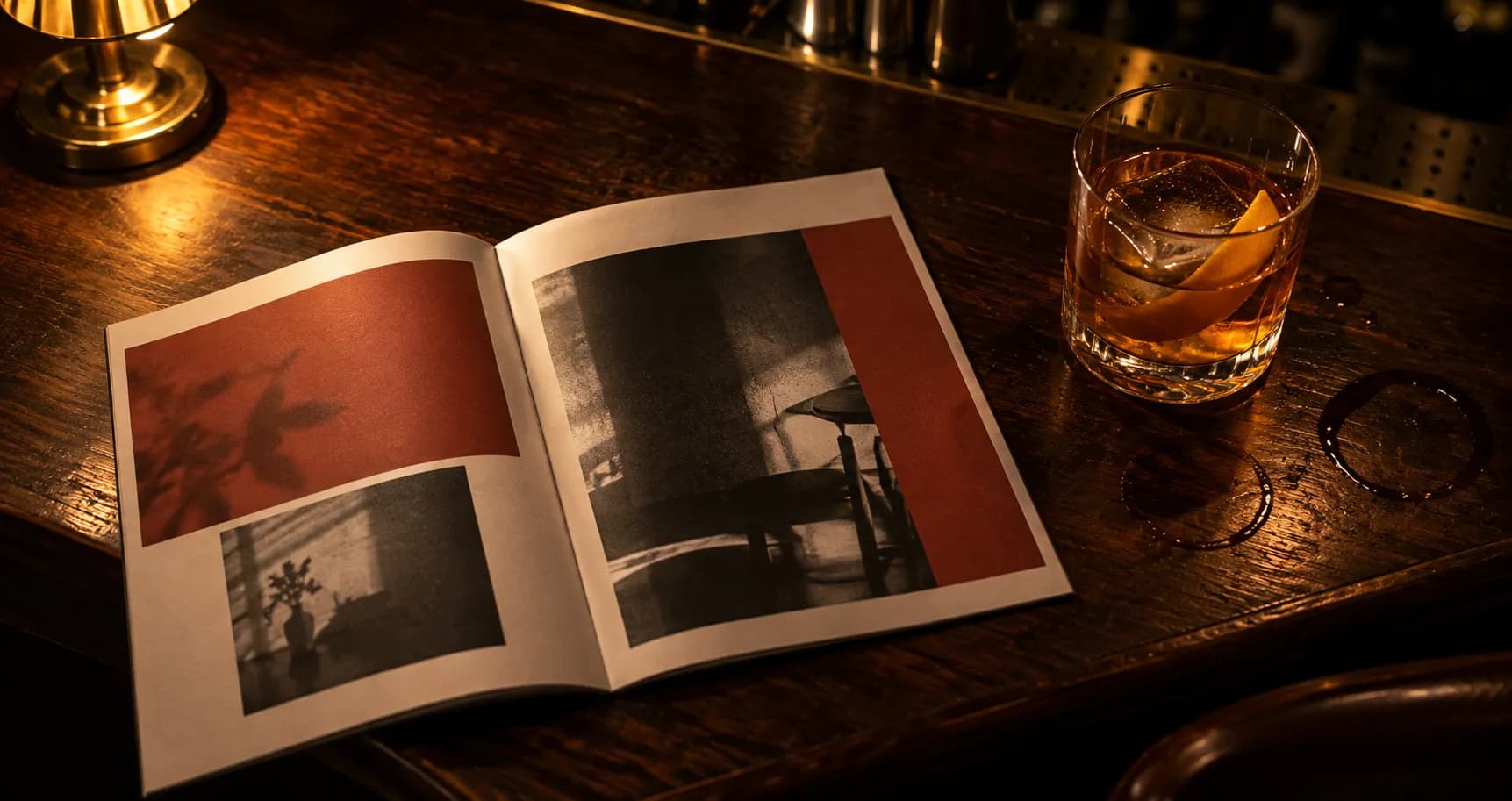 An open printed booklet lying on a bar counter beside a stirred cocktail