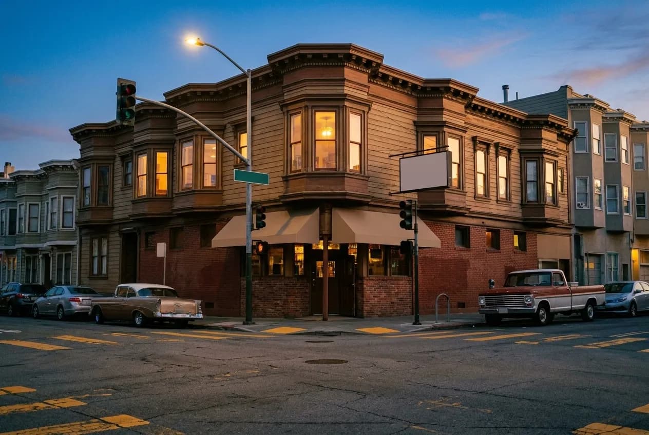 A bar exterior on a San Francisco corner at dusk with warm light in the windows