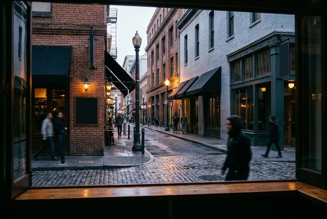 A narrow San Francisco street at dusk with bar frontages and painted brick