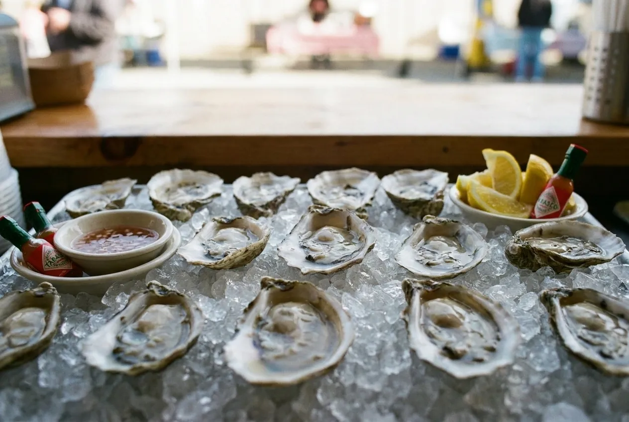 Fresh raw oysters on the half shell served on ice with mignonette, lemon, and condiments.