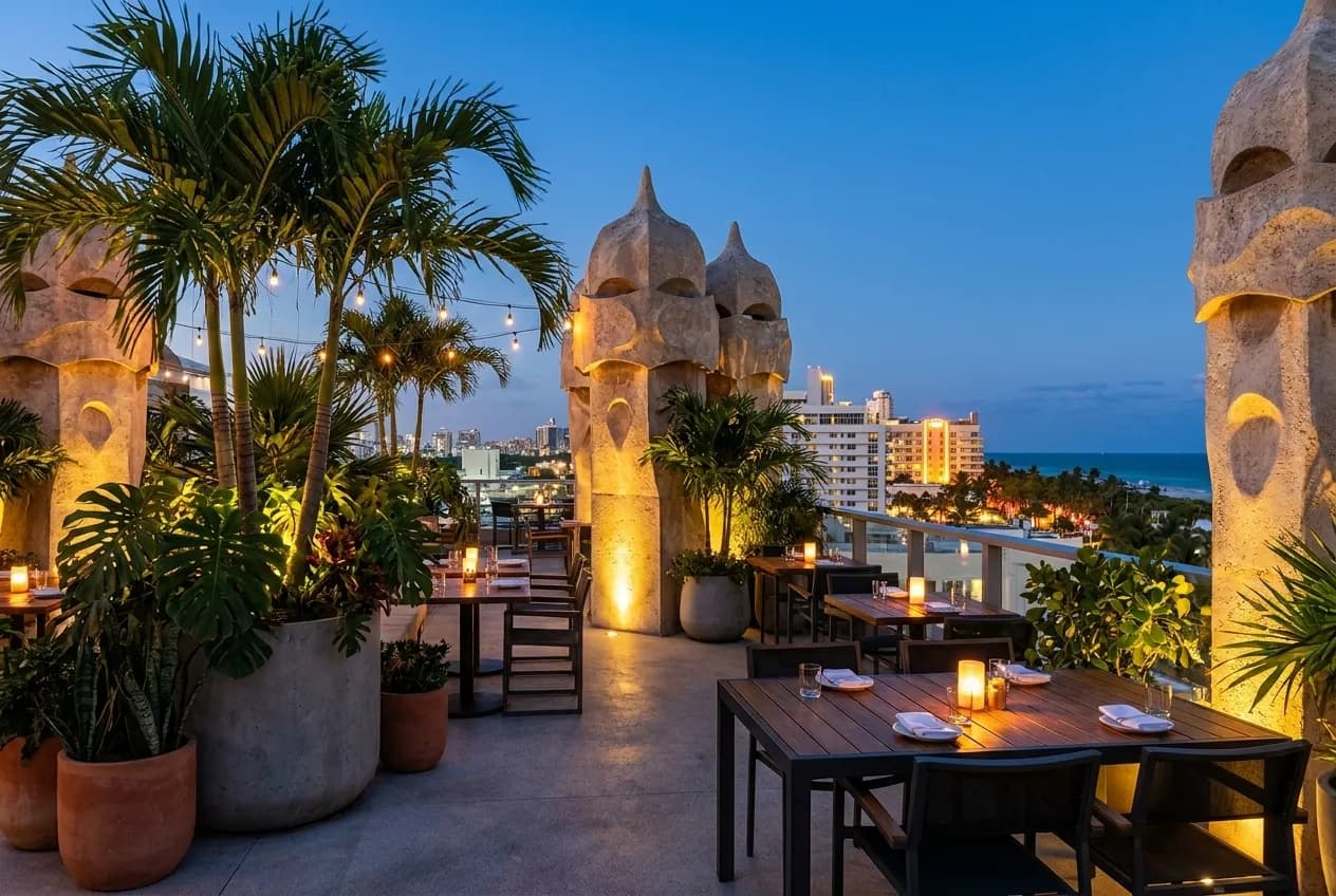 An upscale rooftop restaurant terrace at twilight with Miami Beach skyline in the background