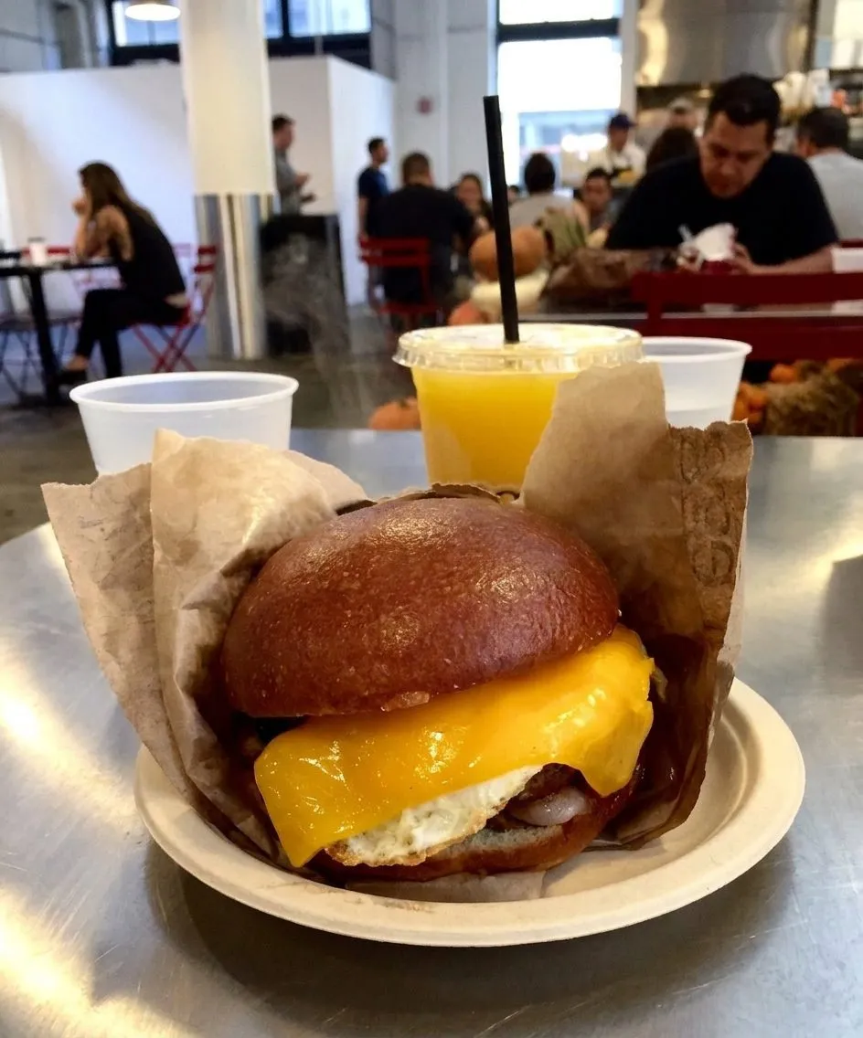 Eggslut breakfast sandwich and coffee on a market table in DTLA