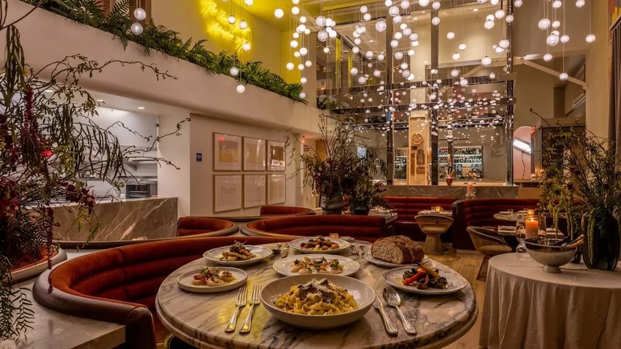 Plated handmade pasta and tasting menu dishes on a polished Los Angeles table.