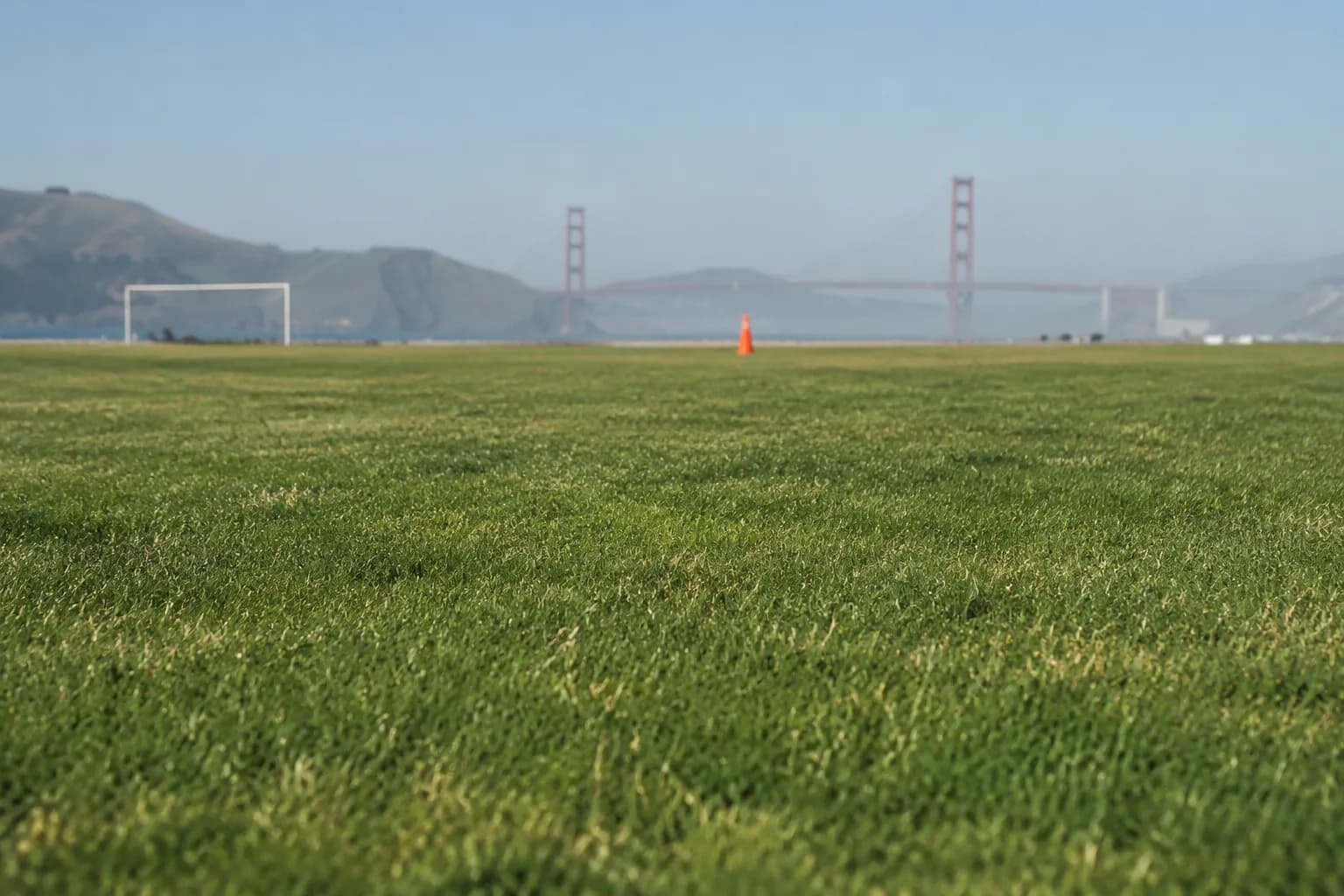 Marina Green grass field with Golden Gate Bridge in hazy distance