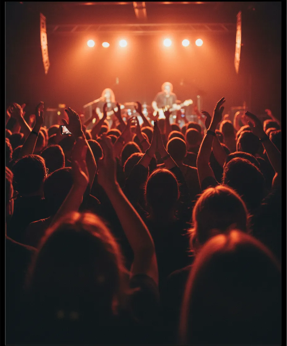 A close crowd at an intimate live gig under warm stage light