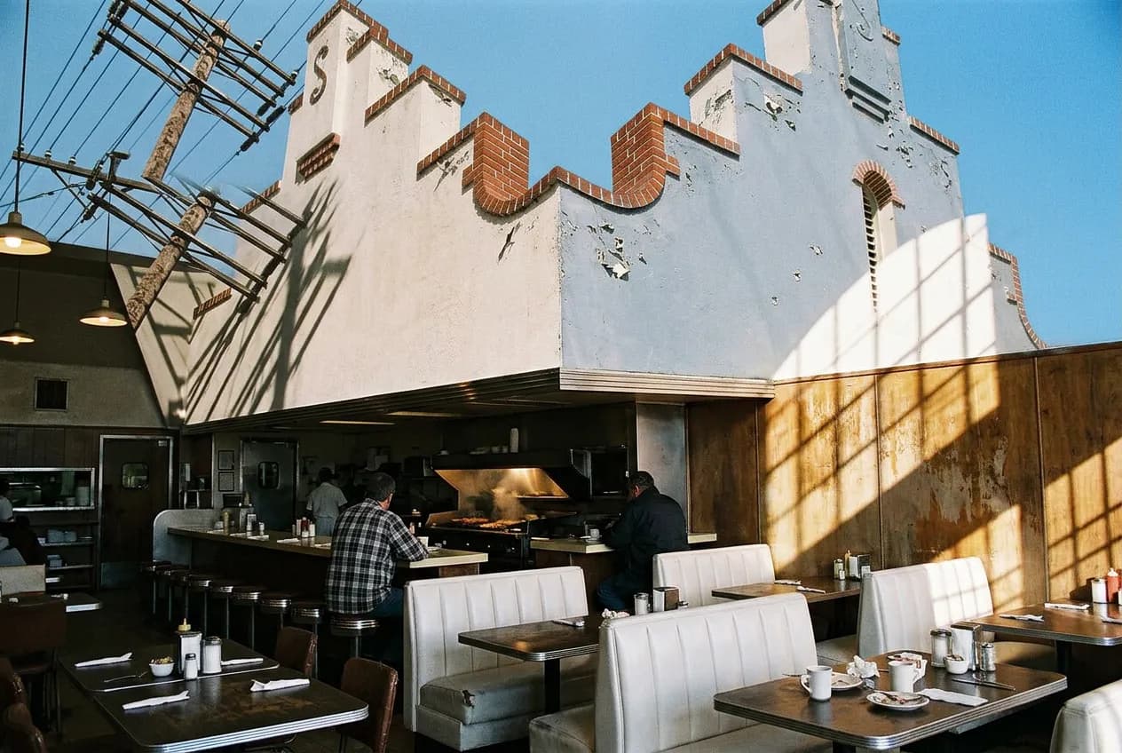 Diner-style booth seating and an open kitchen counter inside a Los Angeles bakery restaurant