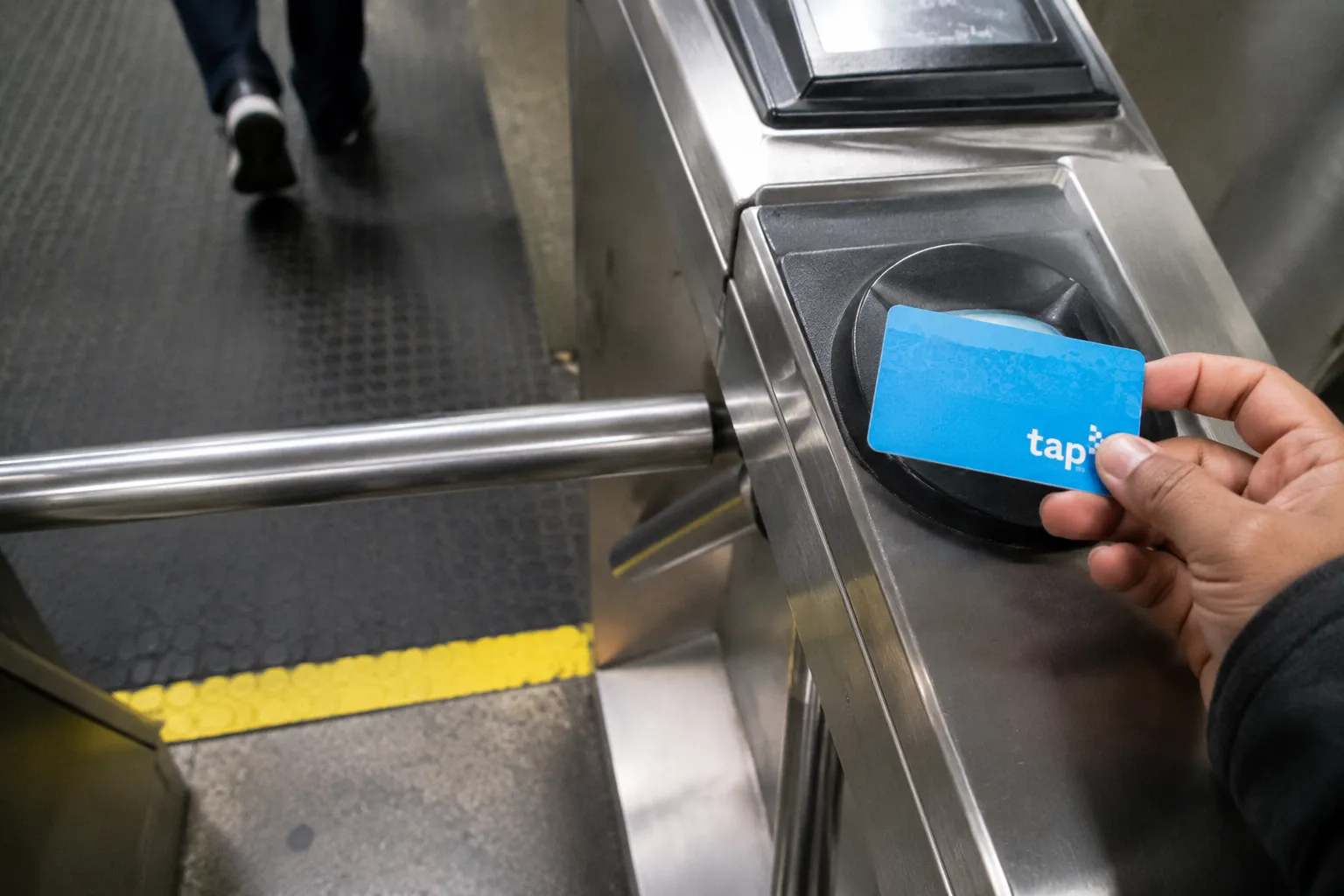 TAP card held over Metro turnstile reader in Los Angeles subway station